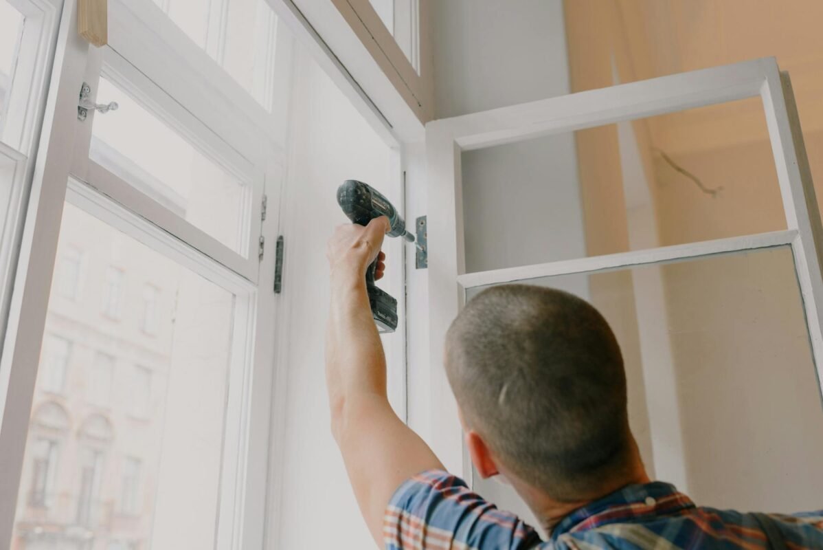 anonymous man installing window in room